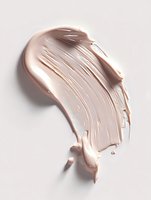 Creamy beige foundation or concealer smear texture on light background showing cosmetic product consistency and coverage for beauty and makeup advertising.