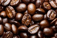 Fresh roasted coffee beans macro background showing rich brown color and natural texture detail for cafe, restaurant, and food industry designs.
