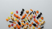 Colorful assorted vitamin pills, capsules and supplements scattered on white background for health and wellness concepts.