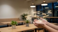 Modern office workspace with hands presenting glowing business development process icons including ideation, prototype, scale and implement concepts.