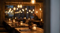 Cozy restaurant interior with warm Edison bulb lighting and wooden tables creating intimate dining atmosphere for evening meals and romantic dates.