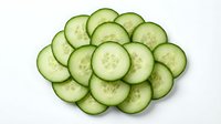 Fresh cucumber slices arranged in circular pattern on white background, healthy vegetable ingredient for salads, cooking and spa treatments.