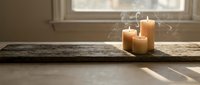 Burning candles on rustic wooden board by window with natural sunlight, creating warm ambiance for home decor, relaxation, meditation or spa wellness settings.