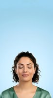 Young woman with curly dark hair and medium skin tone wearing sage green shirt against light blue background, eyes closed in peaceful expression, suitable for wellness and mental health content.
