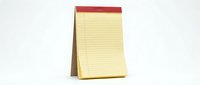 Yellow lined notepad with red header standing upright on white background, office supplies for writing notes and reminders in workplace or home.