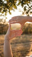Female hands forming frame gesture in golden sunlight with blurred autumn trees background for creative photography and vision concepts.