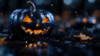 Glowing carved black pumpkin with water drops and orange light inside on dark background with bokeh lights, halloween decoration with mystical atmosphere.