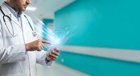 Male doctor using digital tablet with glowing network connections in modern medical facility for healthcare technology and telemedicine applications.