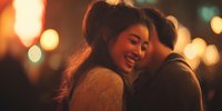 Young couple embracing intimately with warm bokeh lights creating romantic atmosphere for Valentine's Day celebrations and love concepts.