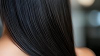 Silky smooth black hair close-up showing healthy shine and straight texture against blurred background. Professional haircare and beauty industry concept.