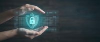Hands protecting glowing digital security shield with padlock icon against dark tech background, representing cybersecurity, data protection, and network safety for business applications.