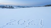 Footprints and tire tracks form numbers 2024 in snow-covered frozen lake landscape with distant forest and mountains under winter sky, suitable for New Year concepts and seasonal marketing.