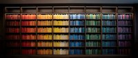Rainbow bookshelf with organized colorful books arranged by color spectrum from red through purple, perfect for library and education design projects.