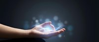 Caucasian hand holding glowing holographic crystal with blue light particles on dark background, suitable for technology, innovation, and digital transformation concepts.