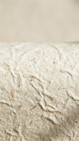 Soft beige textured wall surface with rough plaster finish and neutral cream background for interior design and architectural projects.