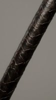 Close-up macro shot of dark brown braided leather cord showing detailed texture and craftsmanship against neutral background for design projects.