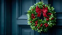 Festive holiday wreath with green boxwood leaves, bright red berries, and elegant red bow hanging on dark blue door.