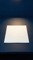 Blank white platform illuminated by warm spotlight against dark blue background, ready for product display or mockup presentations.
