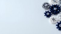 Decorative mechanical gears in navy blue, white and silver with rhinestone centers arranged in corner composition on light background, copy space for text.