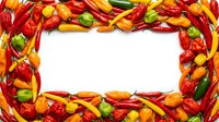 Colorful chili peppers in red, yellow, and green arranged as a border frame around white space, suitable for food packaging, recipe cards, and culinary designs.