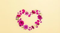 Heart-shaped floral arrangement with pink and purple flowers on cream background for romantic designs and Valentine's Day projects.