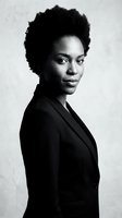 Professional African American businesswoman with natural afro hairstyle in black suit jacket portrait for corporate branding and leadership concepts.