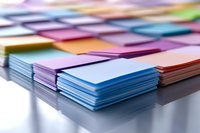 Stacks of colorful paper notes arranged in neat rows on white surface with soft focus background, suitable for office and organization concepts.