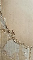 Cracked and peeling paint on old wall surface showing layers of weathered coating with natural aging texture for renovation and restoration projects.
