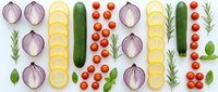 Fresh vegetables arranged in colorful rows including red onions, yellow squash, cucumber, cherry tomatoes, rosemary and basil on white background.