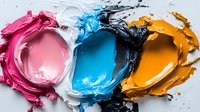 Vibrant cosmetic cream texture swatches in pink, white, blue, black and orange colors smeared on white surface showing rich creamy consistency and pigmentation.