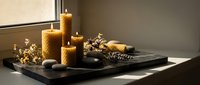 Beeswax candles with natural decorative elements arranged on black tray near window, creating warm ambient lighting for home decor and relaxation.