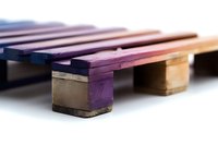 Colorful wooden xylophone keys in purple and natural wood tones photographed in macro with selective focus and soft lighting, creating musical instrument abstract.