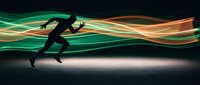 Dynamic silhouette of athletic runner in motion with flowing green and orange light trails creating energy waves on dark background for sports concepts.