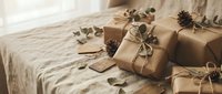 Eco-friendly gift boxes wrapped in brown kraft paper with natural twine and dried eucalyptus leaves on linen fabric for sustainable holiday packaging.