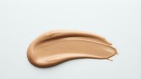 Smooth beige foundation makeup smear stroke isolated on white background for cosmetic beauty product advertising and skincare branding materials.