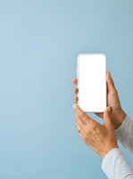 Mature man with medium skin tone holding smartphone with blank white screen against light blue background, suitable for app mockups and mobile technology marketing.