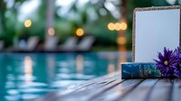 Luxury resort poolside evening scene with tablet computer and purple flower on wooden deck with bokeh lights background.