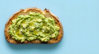 Fresh avocado toast on artisan bread with sea salt flakes, healthy breakfast or brunch meal on blue background for food photography and culinary content.