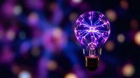 Plasma filaments glow inside vintage lightbulb against blurred neon purple and blue bokeh background, representing innovation, energy, and creative ideas for technology and science concepts.