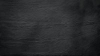 Dark gray slate stone texture with natural rough surface and organic patterns for modern interior design backgrounds.