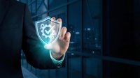 Businessman in dark suit touching glowing shield with checkmark icon, representing cybersecurity, data protection, and digital safety solutions for enterprise networks.