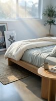 Serene bedroom interior with wooden bed frame, cream and sage bedding, potted plant, framed botanical art, and natural sunlight from large window for home decor and lifestyle design.