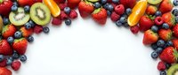 Fresh mixed berries and fruits frame on white background with copy space for healthy eating and nutrition concepts.