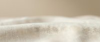 Closeup of natural linen fabric with soft folds and neutral beige tone, suitable for textile, fashion, and interior design projects.