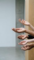 Diverse group of hands reaching out together in a modern interior, symbolizing unity, teamwork, and collaboration in a multicultural community.