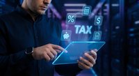 Businessman using digital tablet with holographic tax calculation interface displaying financial icons and percentage symbols in modern office environment.