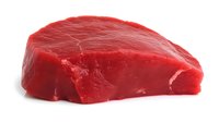 Fresh raw beef steak piece isolated on white background, bright red meat cut showing marbling and texture, ready for cooking or food design projects.