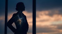 Woman silhouette with glowing lightning bolt on chest against sunset sky, representing power, energy, and inner strength for wellness and motivation concepts.