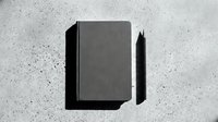 Closed dark notebook with black pen on concrete textured surface, flat lay composition for stationery, office supplies, and business branding mockup projects.