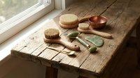 Natural spa wellness tools arranged on rustic wooden table by window with soft sunlight for relaxation and self-care routine.